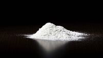 A small pile of white powder on a dark surface