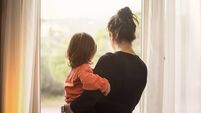 Mother and son looking out of window