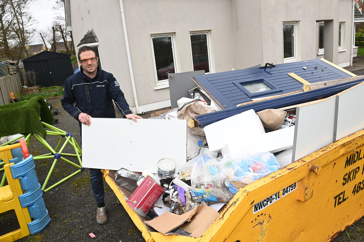  Alan Mahy with a skip of flood-damaged items.