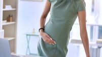Shot of a young pregnant businesswoman standing alone in the office and suffering from abdominal pain