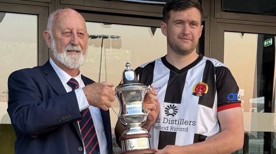 Sean O'Sullivan, Munster Senior League, presents the Beamish Stout Senior Premier Division trophy to Midleton captain Jake Hegarty.