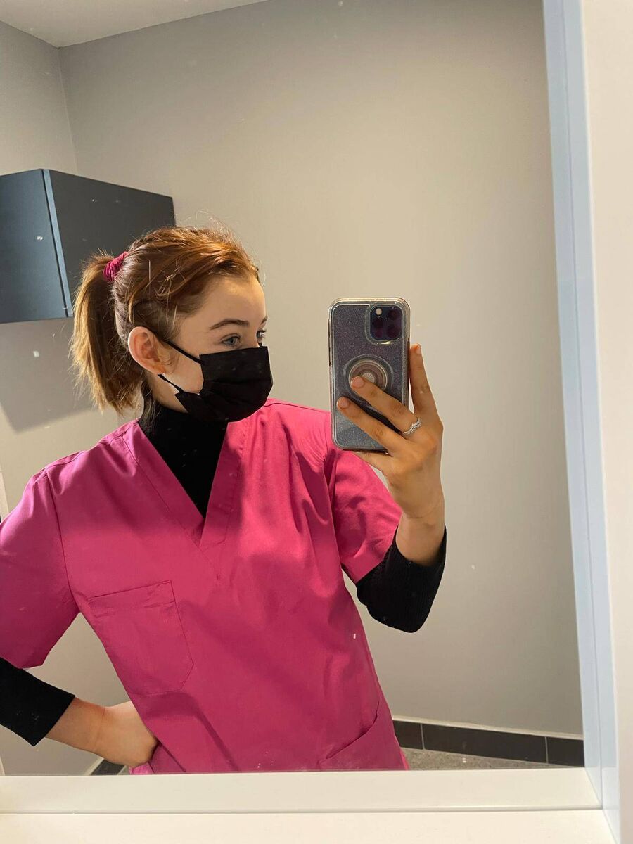 Orla Barry in her embalmer scrubs. She was born hard of hearing but lost all hearing in her left ear in 2022, with only about 20% remaining in her right. “It is scary, but I’ve adapted so well,” she says 