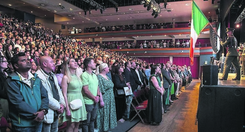 New Irish citizens stand to attention for the national anthem after they received citizenship at a ceremony in Gleneagle Killarney yesterday.	Pictures: Don MacMonagle
                    