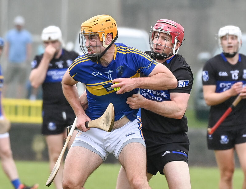  Carrigtwohill's Liam O'Sullivan keeps possession under pressure from Sarsfields' Daniel Kearney, during their SHL clash at Carrigtwohill.