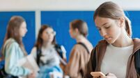 Portrait of female high school student using phone