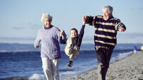 Grandparents Playing With Grandson on Beach
