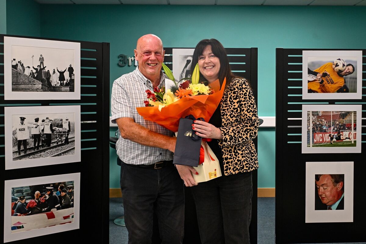 Gráinne McGuinness, editor of The Echo, presents a bouquet of flowers to Eddie O’Hare at a celebration marking his retirement after 47 years as one of Cork’s most celebrated press photographers. Picture Chani Anderson