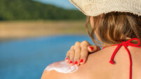 Young woman applying sun lotion on summer vacation