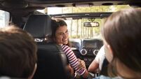 Family Driving In Open Top Car On Countryside Road Trip
