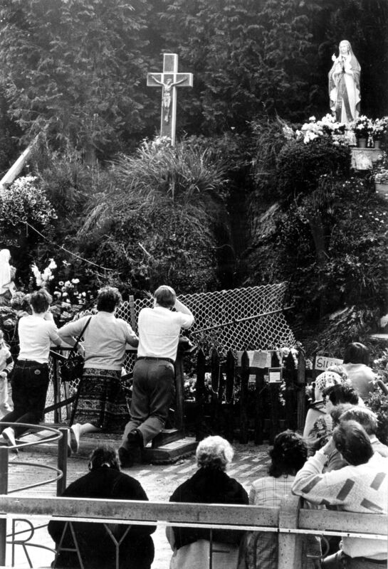 Visitors pray at the grotto that summer