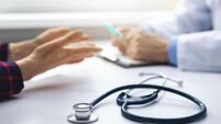 medical consultation - doctor talking to patient in clinic office. focus on stethoscope