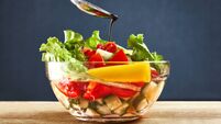 Concept healthy organic vegetarian meal,Pouring olive oil in the salad over a spoon.