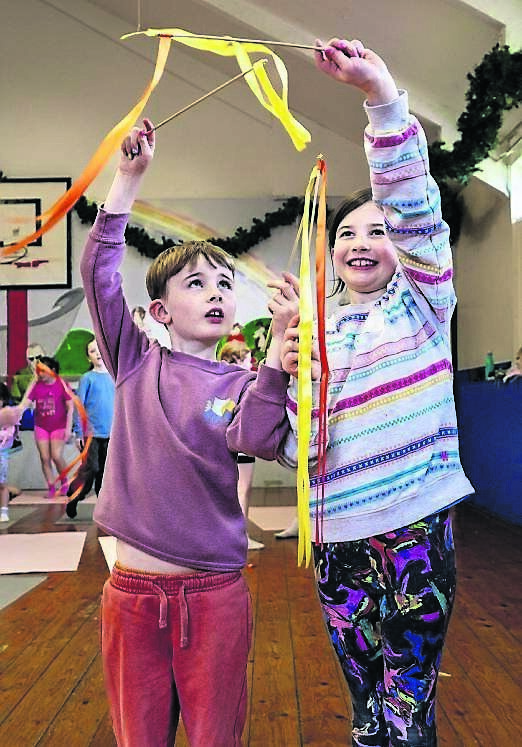 Mae and Oran dance with ribbons at a movement session at the Happy Vibes Kids Camp