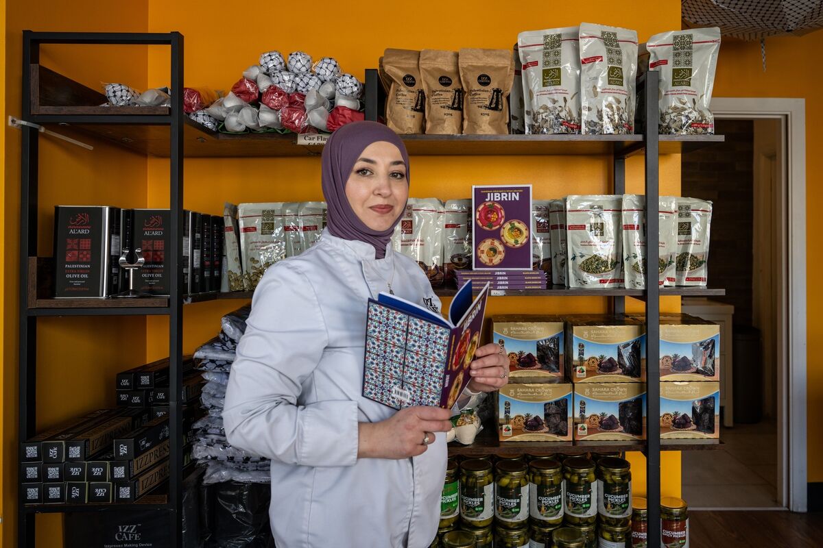 Eman Alkarajeh pictured in Izz Café with the new cookbook, Jibrin. Picture Chani Anderson.