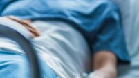 In the Hospital Sick Male Patient Sleeps on the Bed. Heart Rate Monitor Equipment is on His Finger.