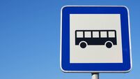 Bus stop traffic sign against blue sky.
