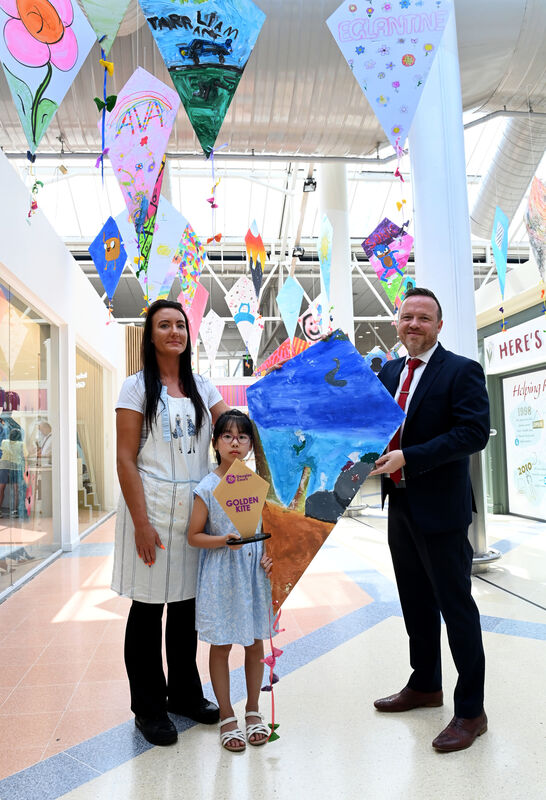  Golden Kite Award winner An Nguyen collected her prize from Klaudia and Alan Moreland, Centre Manager at the Kite Festival HQ at Douglas Court Shopping Centre.
