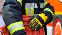 Firefighter wearing a rolled hose