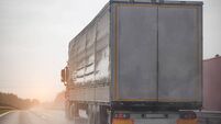 A semi-trailer truck drives on a wet road during poor visibility and rain. Bad foggy and rainy weather. Copy space for text