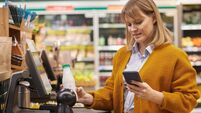 Woman Scanning Groceries at Self Checkout in Supermarket