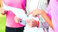 Girl Pointing At Test Result While Standing With Students