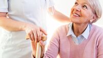 Close-up of person touching hand of senior woman. Home assistance concept. Elderly female hand holding hand of young caregiver a