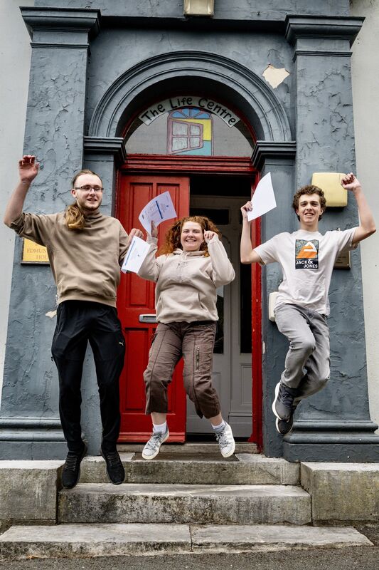 A joyful moment at the Cork Life Centre as Jack O’Leary, Francesca Ring and Kevin Riordan leap from the steps with their Leaving Cert results in hand. Picture Chani Anderson