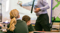 Primary school girls are taught during a lesson by a male teacher