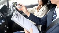A woman and a male instructor during driving lessons