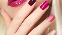 Burgundy colored manicure .