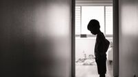 Sad boy standing alone in the hallway