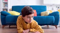 Young Child Engrossed in Reading a Colorful Book on Floor