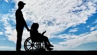 A disabled girl in a wheelchair and her dad on a walk reading a book