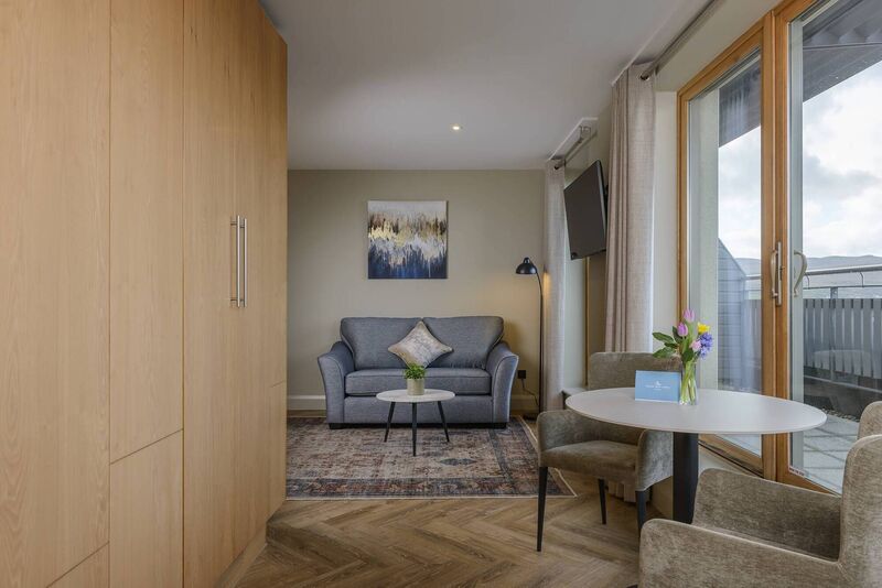 The Suites in Manor West Hotel offer a spacious blend of comfort and style, featuring a beautifully appointed bedroom and lounge area.