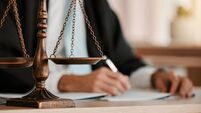 Closeup, scales and law on table, office and attorney man in blurred background with reading for crime analysis. Advocate, lawye