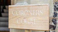 A wooden sign showing the words Coroners office
