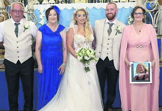 The couple with Clara’s parents, Gerard and Anne, and Michael’s mother Catherine, holding a photo of his late father, Paul McNamara