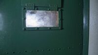 Window on a green prison door