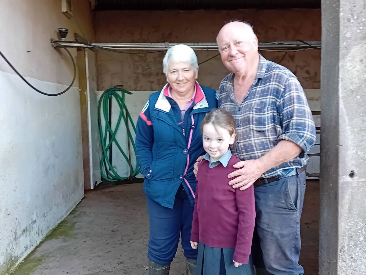 John Arnold with his wife Mary and their grandchild at his final milking in Bartlemy