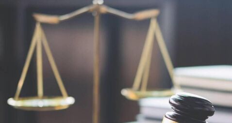 Scales of justice and Gavel on wooden table and Lawyer or Judge working with agreement in Courtroom, Justice and Law concept