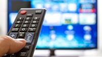 Television remote control changes channels thumb on the blue TV screen
