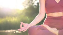 Woman practicing Padmasana on yoga mat on wooden pier near pond, closeup with space for text. Lotus pose