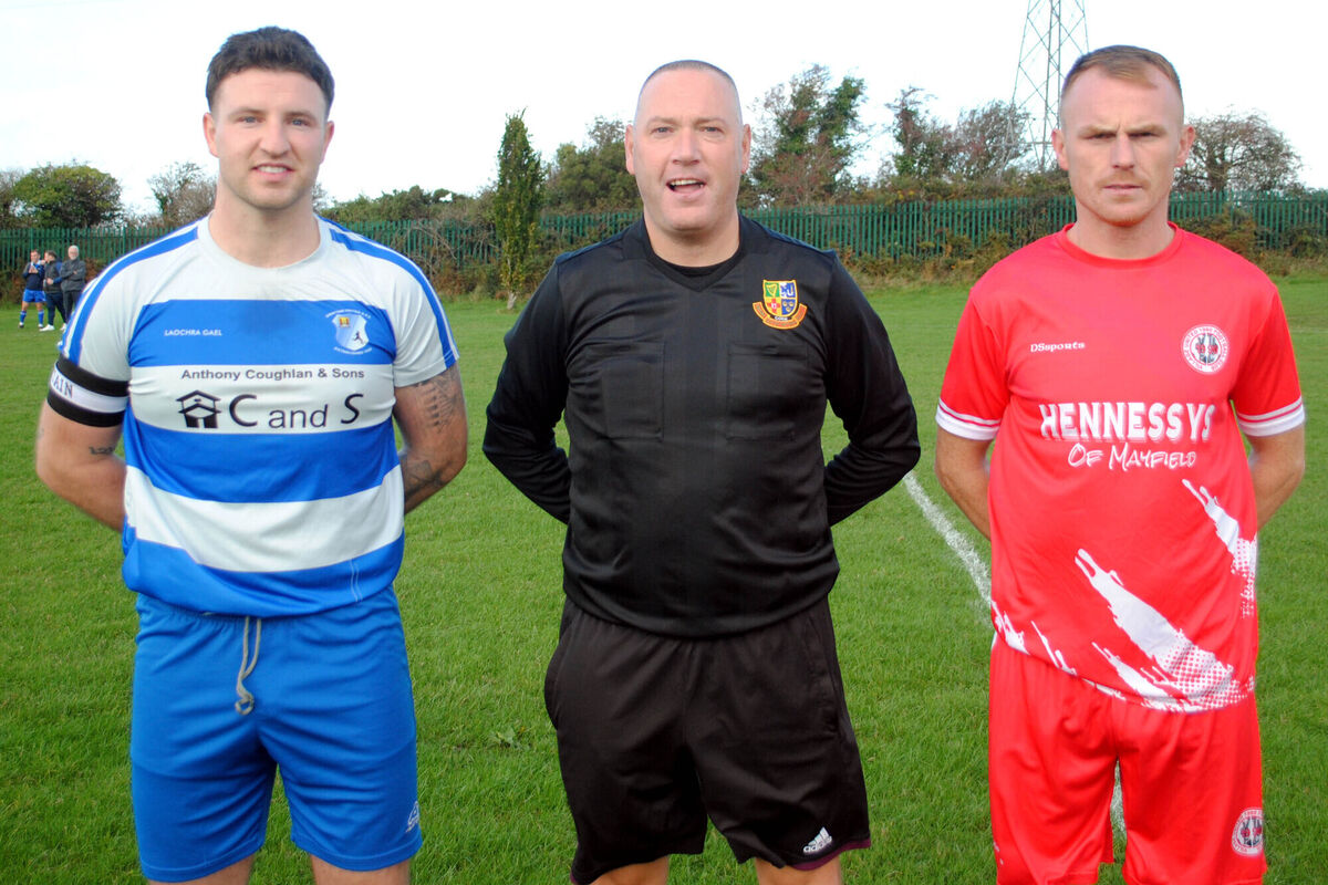 Grattan United's captain Adam Lee Reynolds (left) with Village United's Anthony Kiniry, accompanied by referee Alan McDonagh.