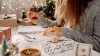 Girl counting US Dollar bills, using calculator, and writing expenses. Woman doing budget, estimating money balance for shopping