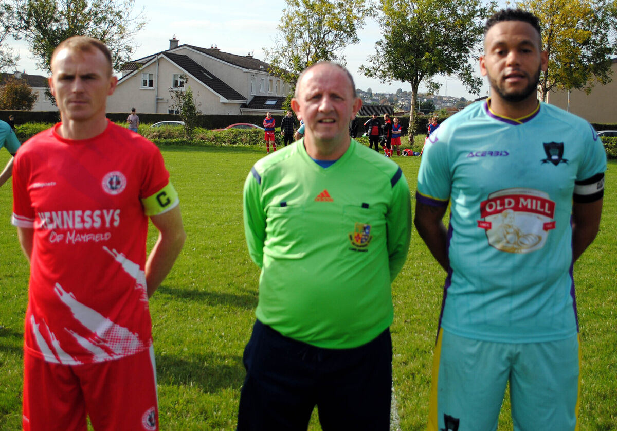 Village United captain Anthony Kiniry (left) with Knocknaheeny Celtic's Chris Akhigbe, accompanied by referee Paul Bowdren.