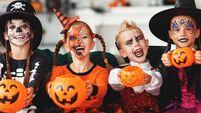happy Halloween! a group of children in suits and with pumpkins in home