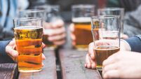 Hands holding glasses with beer on a table in London
