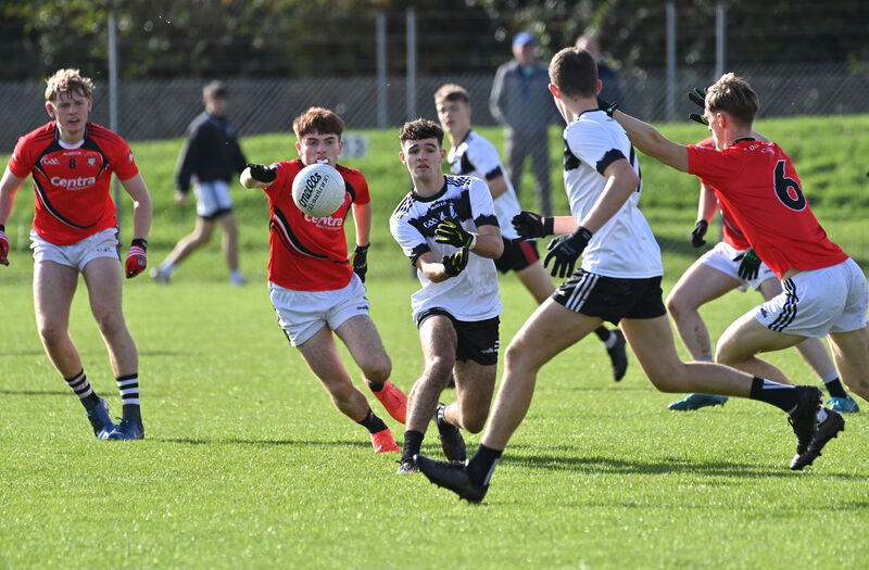  Aidan O'Sullivan of Pobalscoil Inbhear Scéine Kenmare getting his pass away under pressure from Liam Kelleher of St Francis College Rochestown. Picture: Dan Linehan