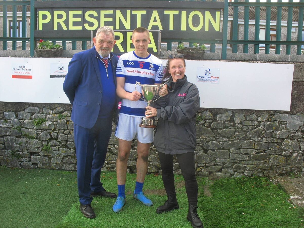 Seandún Chairman Mick Buckley and Jess O'Sullivan (Managing Director of AOS Security) present the trophy to Ballyphehane captain Cian O'Brien 