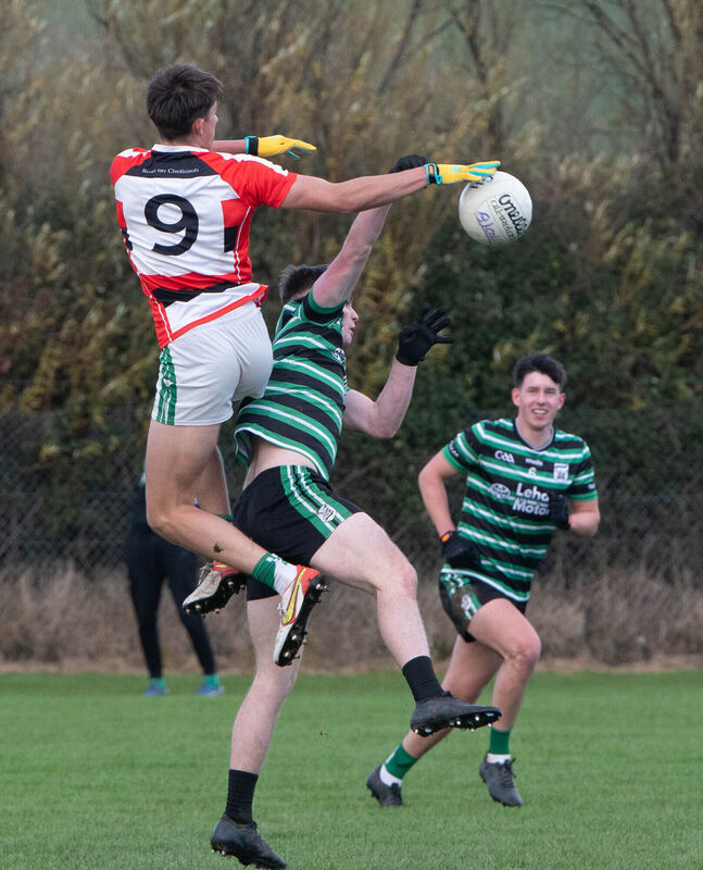 Ballincollig's Ben O'Connell jumps high to knock on a loose ball ahaead of Jack O'Brien of Douglas. Picture: Howard Crowdy Ballincollig's Ben O'Connell jumps high to knock on a loose ball ahaead of Jack O'Brien of Douglas. Picture: Howard Crowdy